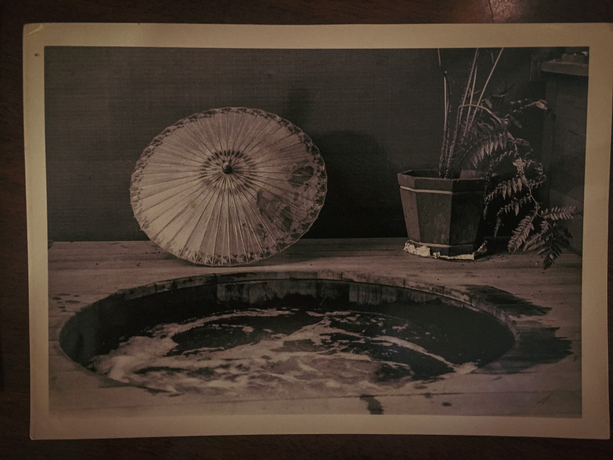 Historical photograph of an early round Almonte Spa tub beneath a parasol