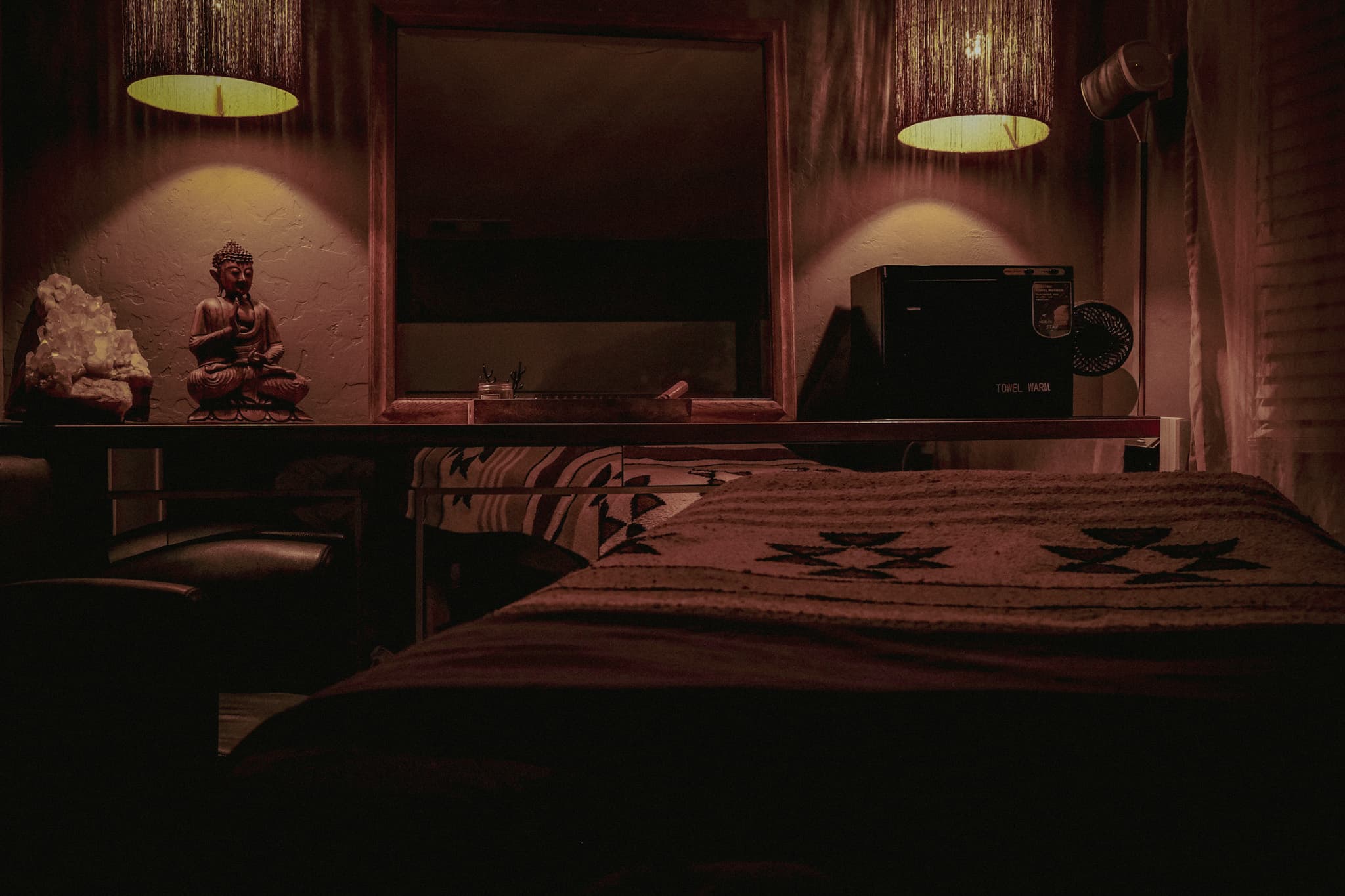 A warm Almonte Spa massage room with a Buddha and crystal