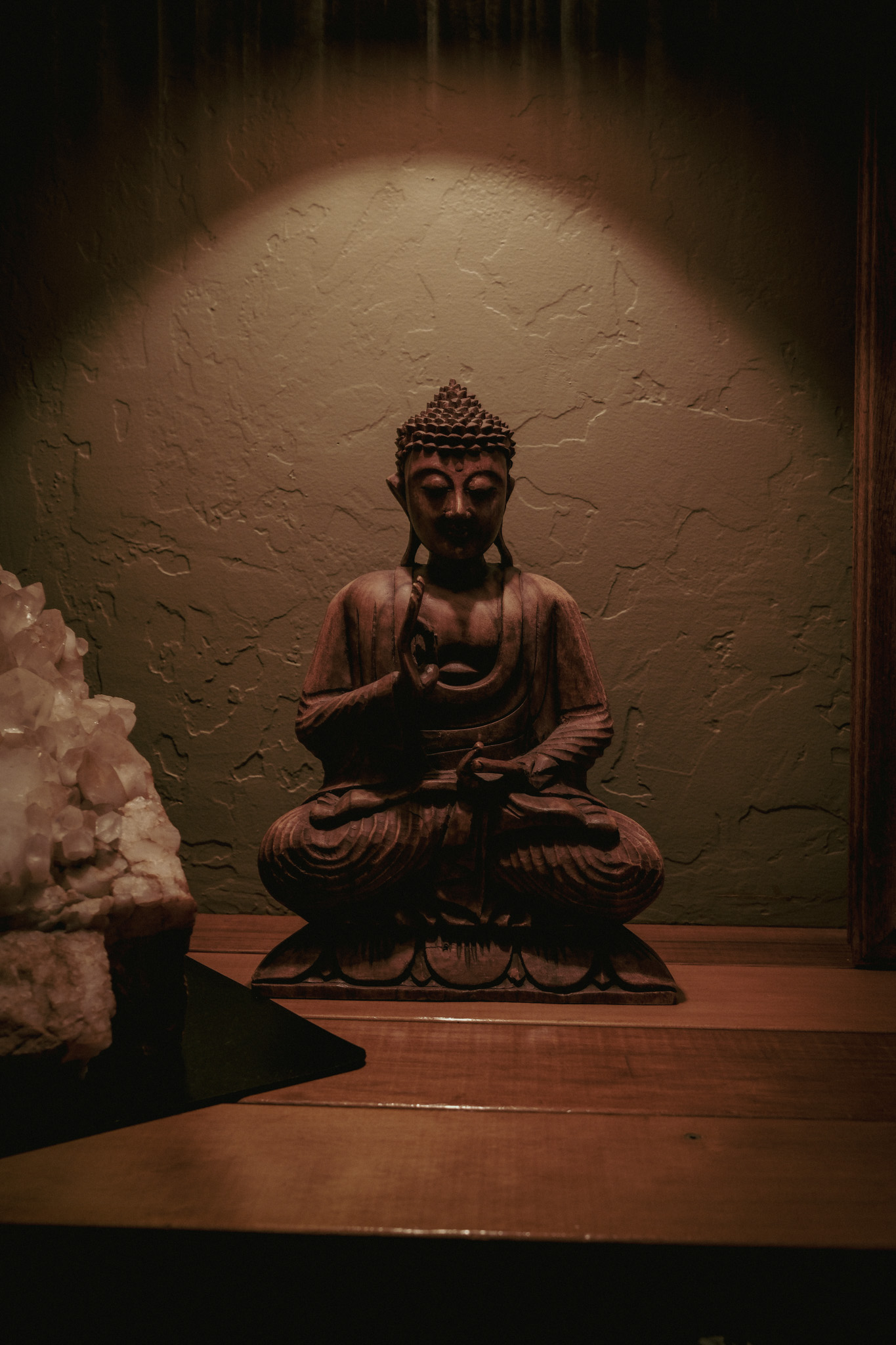 A small Buddha and crystal beneath warm light inside Almonte Spa